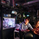 Matthew Chow, center, and Bethany Little discuss with Yuan-Yu Jau, off camera, the first practical way to detect atom loss for neutral atom quantum computing at Sandia National Laboratories. Credit: Craig Fritz, Sandia National Laboratories