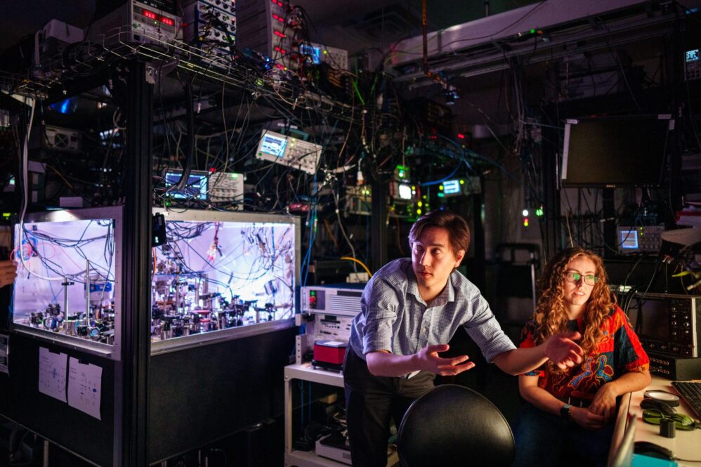 Matthew Chow, center, and Bethany Little discuss with Yuan-Yu Jau, off camera, the first practical way to detect atom loss for neutral atom quantum computing at Sandia National Laboratories. Credit: Craig Fritz, Sandia National Laboratories